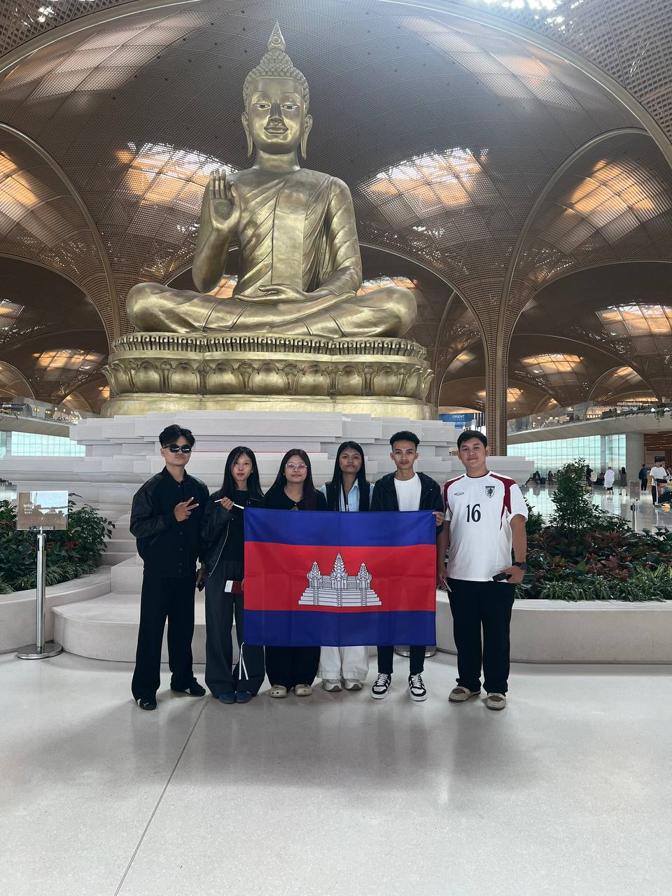 Komnot team holding the Cambodian flag before travelling to Hanoi